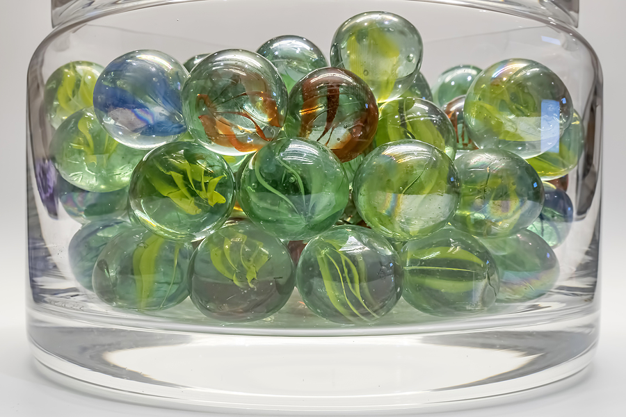 Close up of coloured marbles in a clear glass jar